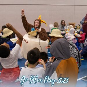 Camp Fire Alaska at Go Blue Day Event with Absolutely Incredible Kid Day Marshmallow with a circle of kids celebrating and engaged