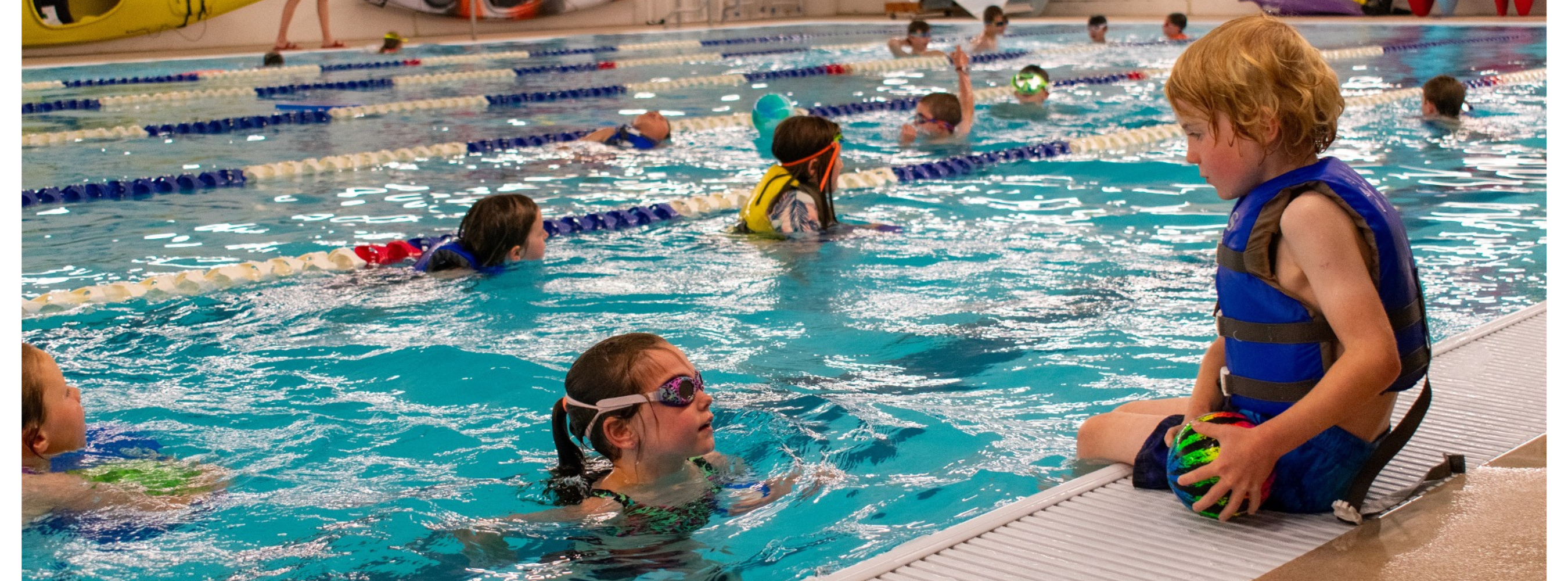 Camp Fire Alaska | Blog Image - Storytelling - A Moment of Connection_ a young girl in a swimming pool encourages her friend to jump into the water