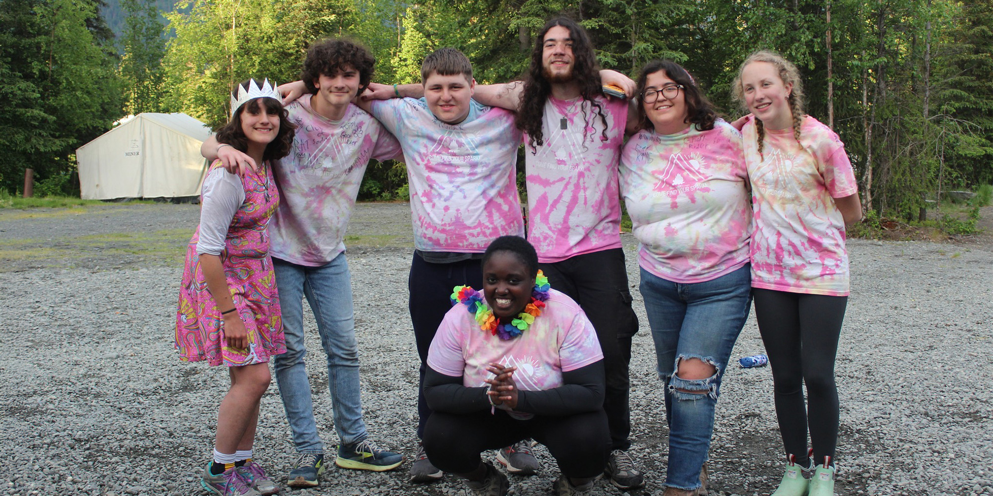 Group of teens in matching tie-dye pink shirts.