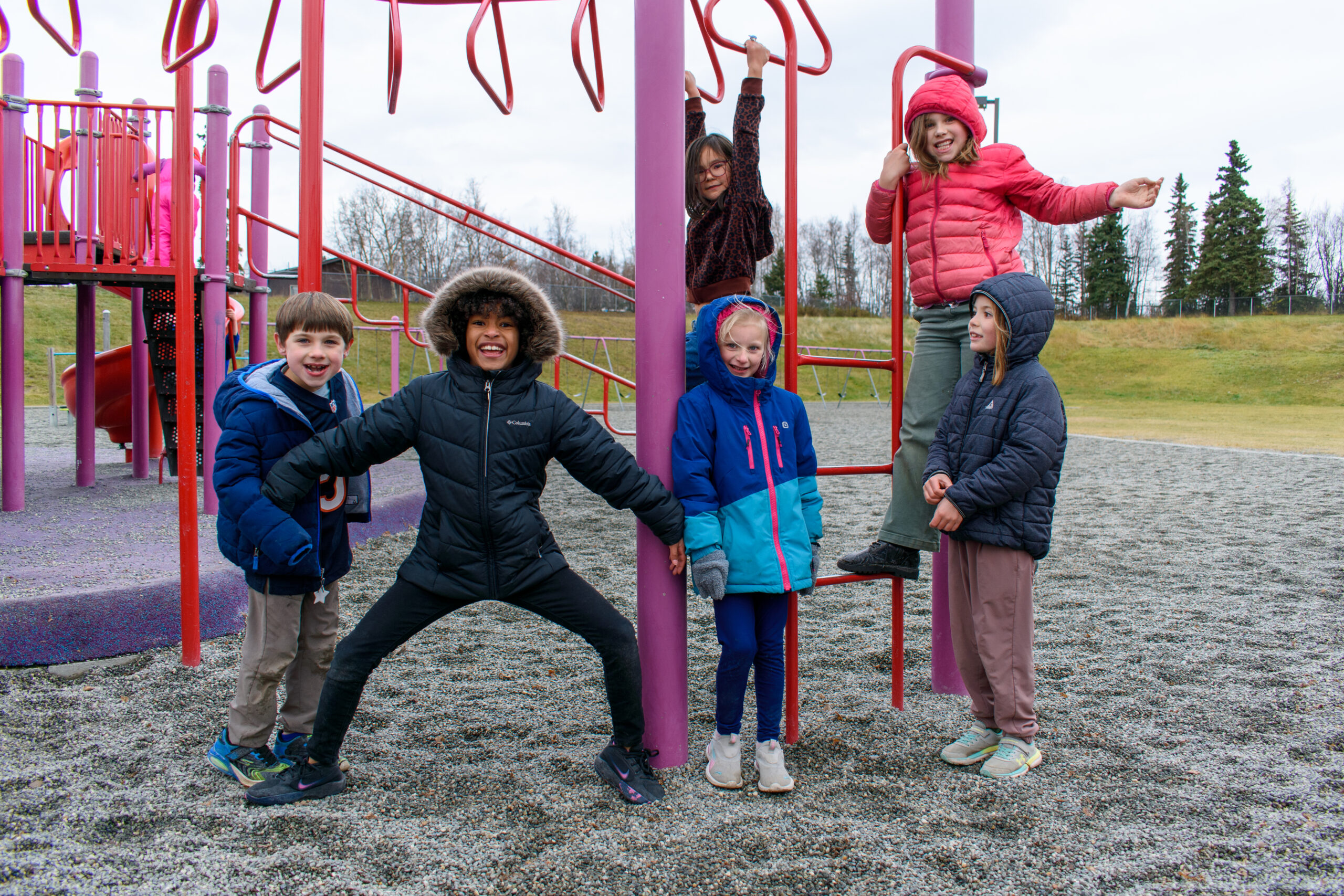 A group of six kids posing on a playground.